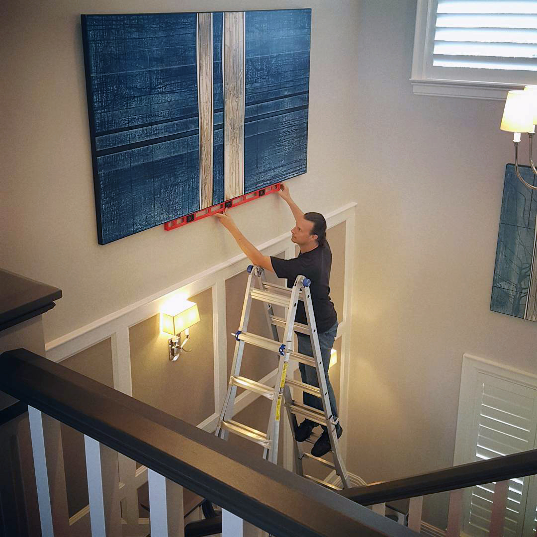 Hanging paintings over stairs