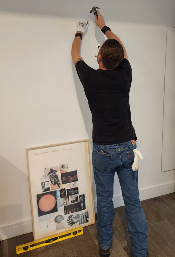 Kris hangs Hanging a Robert Rauschenberg piece